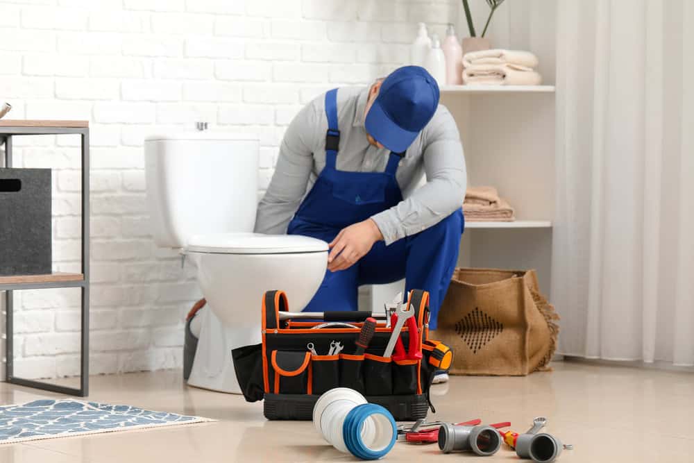 Handsome,Plumber,Repairing,Toilet,Bowl,In,Bathroom